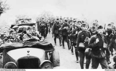 During the invasion of Poland German troops move down a road past German staff cars